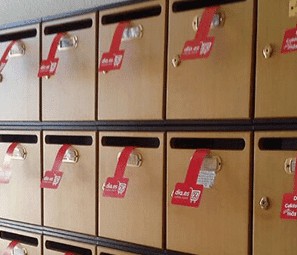Hileras de buzones de madera con muestras impresa de folletería publicitaria que sobresale para vender más